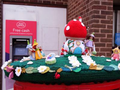 Pretty sure I've never seen a double postbox like this anywhere else. Definitely not seen a postbox topper on one before Knitted fairy-tale Easter scene with toadstool house and figures on top of a red postbox.
