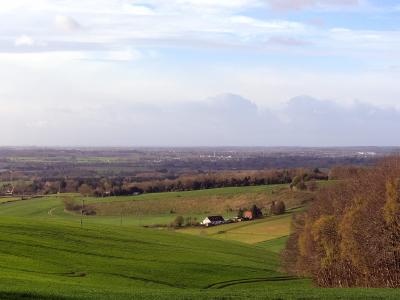 Looking towards Ashford from the North Downs Wide view of rolling green Kent farmland with scattered houses and distant trees.